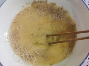 碗中放入三个鸡蛋，一勺椒盐，10克酵母粉，800克温水搅拌均匀！（没有椒盐的也可以放盐和十三香！）