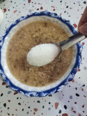 取了一大碗稍微浓稠一点的绿豆粥，加入适量的白糖搅拌均匀！【要比平时喝粥要稍微甜一点儿，因为经过冷冻，甜味会下降！】剩下的绿豆粥当晚餐！