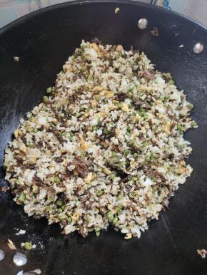 放入剩米饭，翻炒3分钟左右！把剩米饭炒散，炒干水分！