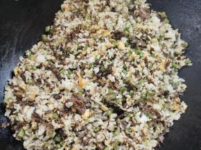 放入剩米饭，翻炒3分钟左右！把剩米饭炒散，炒干水分！