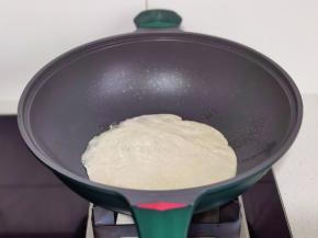 手抓饼放入锅中。