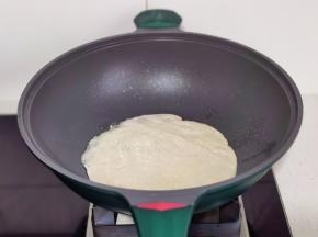 手抓饼放入锅中。