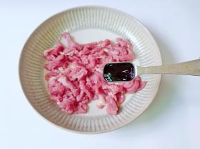 把切好的猪肉丝放在碗里，加蚝油一勺。