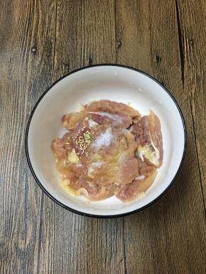 鸡腿去骨去皮，用刀背剁一剁然后切块，放入碗中，调入盐和鸡精。