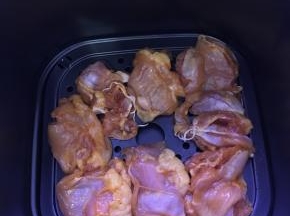 空气炸锅200度预热10分钟后，放入腌好的鸡腿肉。