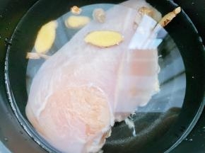 鸡胸肉放入锅里加入料酒，姜片和水，煮15分钟左右至熟透