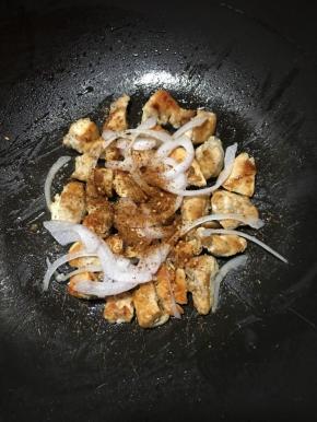 煎至熟透表面呈金黄色，撒上洋葱丝和孜然粉，转大火，用筷子翻拌均匀即可关火。