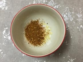 碗里加入盐和鸡精，倒入烧烤粉。