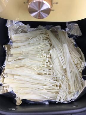 空气炸锅提前200度预热10分钟，铺上锡纸，放入洗净沥干水分的金针菇。