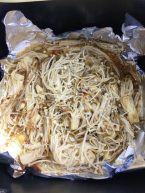 10分钟后将调好的酱汁倒入金针菇里，用筷子翻拌均匀。