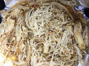 10分钟后将调好的酱汁倒入金针菇里，用筷子翻拌均匀。