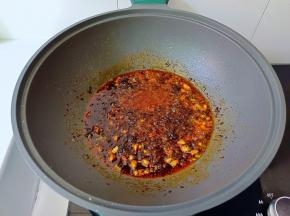 锅里放蒜，火锅底料，辣椒酱炒香。