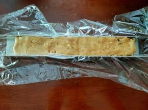 将面团放保鲜膜上，稍微搓成长条，然后放入饼干模具中整形