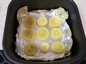 空气炸锅炸篮里铺上锡纸，放上切好的柠檬片。 