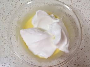 打发好的蛋白分成三份，取三分之一加入到蛋黄糊里面，用硅胶刮刀采用切拌和翻拌的方法混合均匀。 
