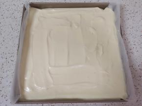 烤盘里铺上油纸，倒入蛋糕糊，轻震几下，用刮刀刮平表面。 