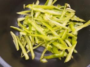 锅里不放油煎先把青椒丝放入煸炒出虎皮状后盛出备用
