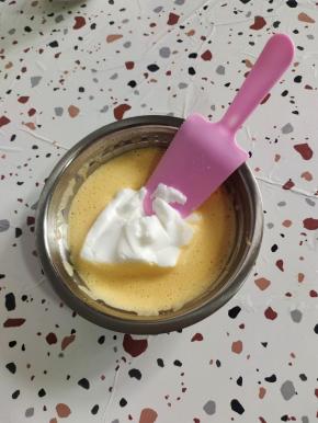 打发好的蛋黄中，放入一勺打发好的蛋白，翻拌均匀！