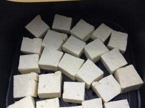 将刷了油的豆腐摆入提前预热好的空气炸锅中。