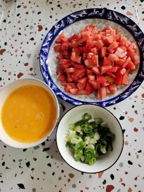 西红柿去蒂切成小丁，葱切成葱花，鸡蛋打散备用！
