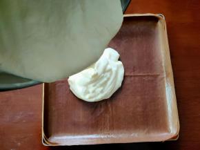 将混合好的蛋糕糊从高处倒入到铺好油布的烤盘中