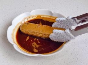 手指饼干放入咖啡液中两面沾满。