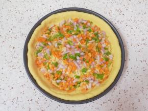 撒上洋葱、胡萝卜和青椒碎。 