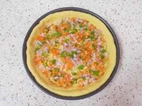 撒上洋葱、胡萝卜和青椒碎。 