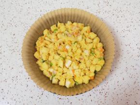 圆形油纸放入披萨盘里，刷上一层食用油，放入混合好的馒头丁铺平。