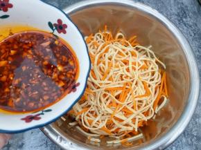 盆里放入放凉的云丝和胡萝卜丝，把调好的料汁倒入