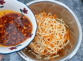 盆里放入放凉的云丝和胡萝卜丝，把调好的料汁倒入