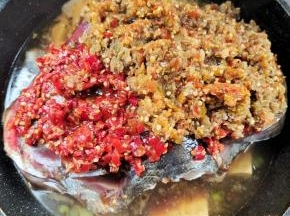 再把剁椒均匀的铺在鱼头上！