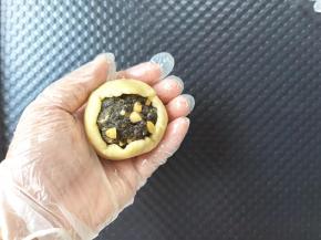 全程带PVC手套。饼皮搓圆，放在左手掌心，用右手掌心按压成薄薄的圆形，放上馅料球，让饼皮贴合到馅料球上。