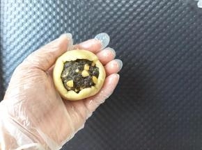 全程带PVC手套。饼皮搓圆，放在左手掌心，用右手掌心按压成薄薄的圆形，放上馅料球，让饼皮贴合到馅料球上。