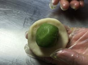 取水油皮面团收口朝上擀成薄饼皮，放入酥油皮面团，包裹严实