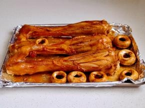 取出蒸好的羊腿，倒掉汁水，刷上腌制羊腿剩下来料汁，羊腿上划几刀，放入口蘑，喷橄榄油，190度蒸汽烤30分钟，取出刷蜂蜜，撒孜然粉，孜然粒，白芝麻再烤5分钟。