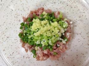 准备好肉馅，放上切碎的小葱和生姜。