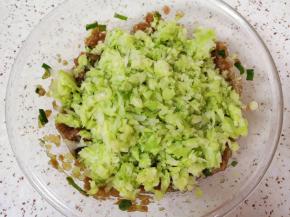 加入挤干水分的包菜碎搅拌均匀。