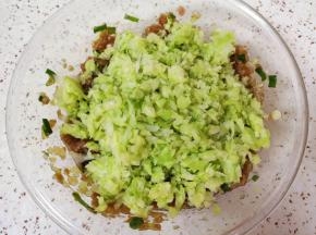 加入挤干水分的包菜碎搅拌均匀。