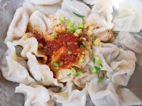 捞出放入大一点的盆里，放上葱花生姜碎，根据自己的口味放上辣椒粉和五香粉，锅里倒入调和油烧热，泼在辣椒粉上面，香味窜出。