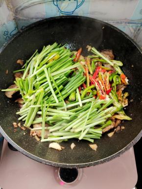 放入辣椒和韭菜梗翻炒均匀！