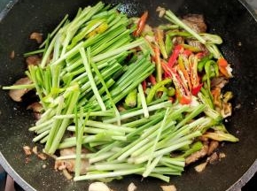 放入辣椒和韭菜梗翻炒均匀！