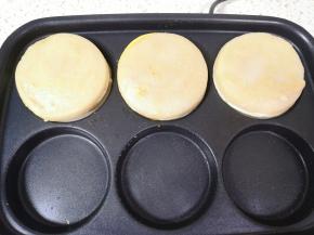 将做好的一半鸡蛋汉堡扣在另一边的面糊上。