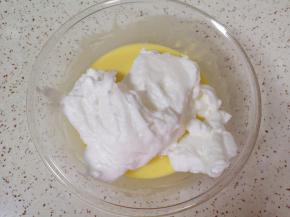 打发好的蛋白分成三份，取中间的三分之一加入到蛋黄糊里面，用硅胶刮刀采用切拌和翻拌的方法混合均匀。烤箱上下管155度预热。