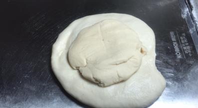 按压成饼，将酥皮面团放在上面，包成包子状