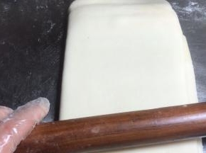再用擀面杖按压擀成长方形面皮