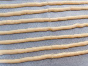 完全挤完后用刮刀从中间切一刀，方便后面分段
放入预热好的烤箱中层先180度烤10分钟膨胀定型，再转150度烤15分钟左右变脆