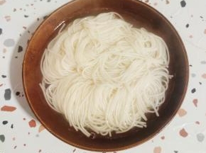 碗中盛入适量的面条，再放入适量的面汤！