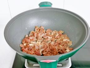 倒入腌制好的牛肉粒，翻炒至变色。