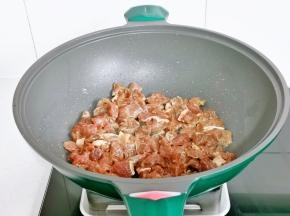 倒入腌制好的牛肉粒，翻炒至变色。